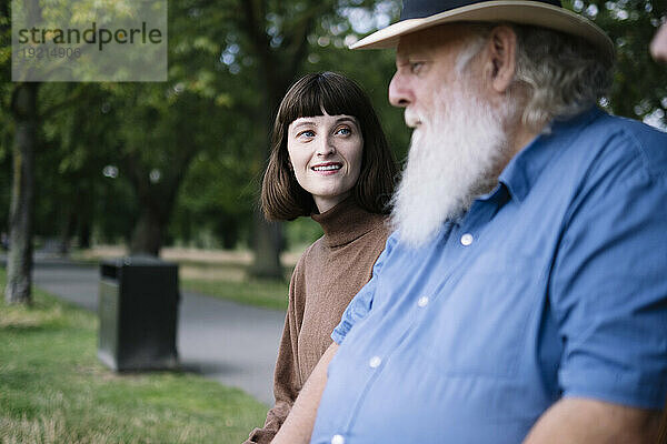 Vater und Tochter sitzen und reden im Park