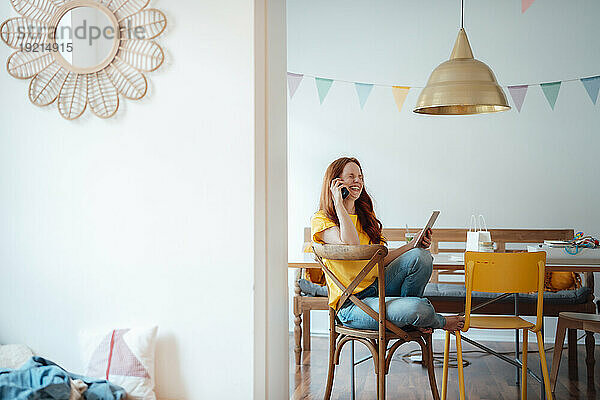 Smiling woman talking on phone at home