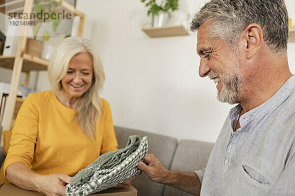 Glücklicher Mann  der der Frau zu Hause ein Geschenk macht