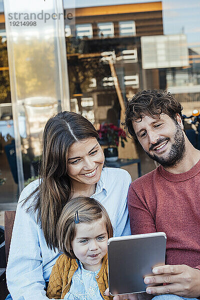 Vater teilt Tablet-PC mit Frau und Tochter