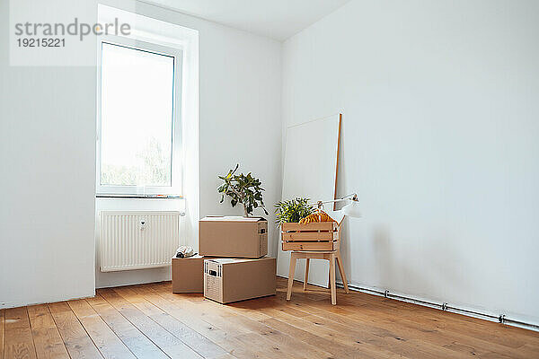 Holzkiste auf dem Tisch mit Kartons auf dem Boden neben der Wand zu Hause