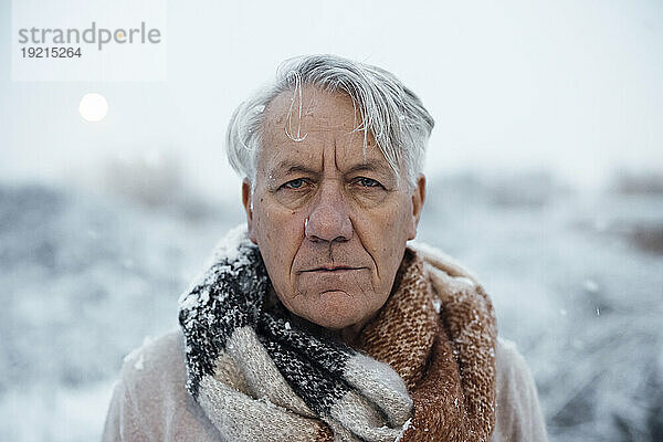 Älterer Mann mit grauen Haaren im Schnee