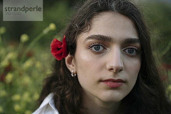 Junge Frau mit Mohnblume im Haar