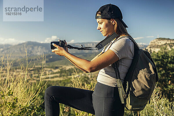 Junge Frau mit Rucksack fotografiert an einem sonnigen Tag