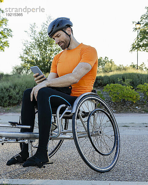 Reifer Mann benutzt Smartphone im Rollstuhl