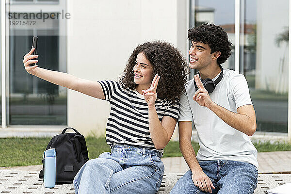 Lächelnde Studenten machen Selfie vor dem Gebäude