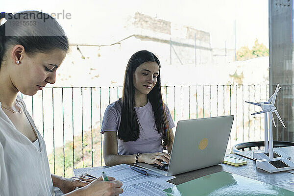 Zwei junge Ingenieurinnen arbeiten am Schreibtisch mit Laptop