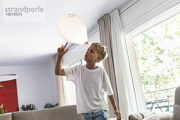 Junge spielt zu Hause mit Ballon