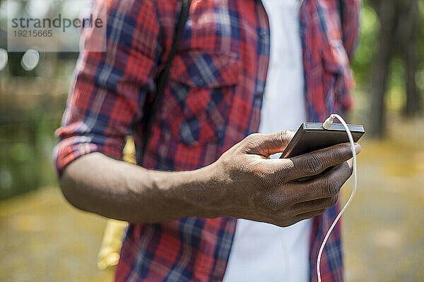 Hand eines jungen Mannes  der sein Smartphone benutzt