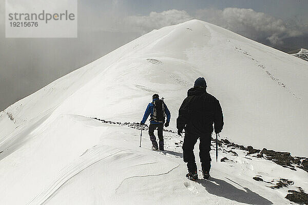 Männer wandern auf schneebedecktem Berg
