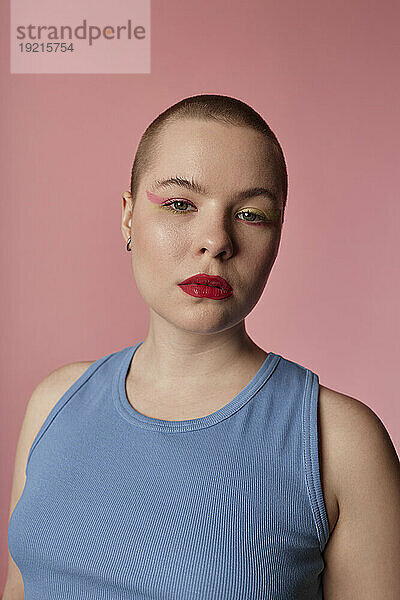 Selbstbewusste junge Frau vor rosa Hintergrund
