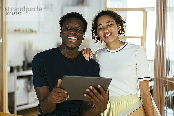 Glückliche Studenten mit Tablet-PC zusammen an der Universität