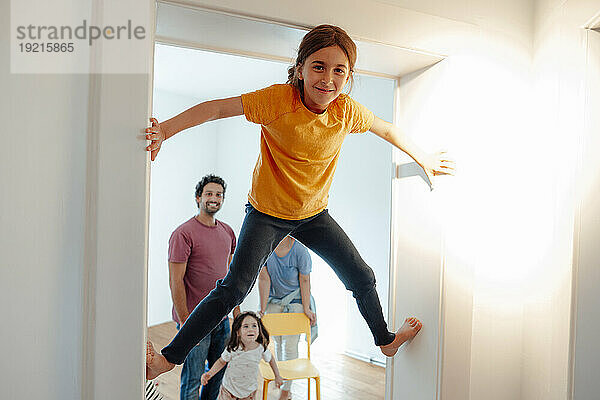 Mädchen klettert mit Familie im Hintergrund an die Wand