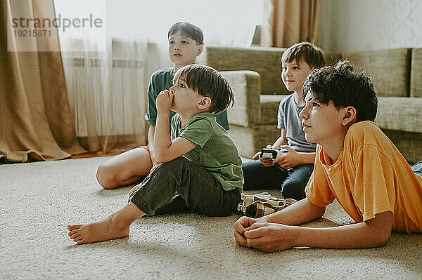 Brüder spielen zu Hause Videospiel auf dem Teppich
