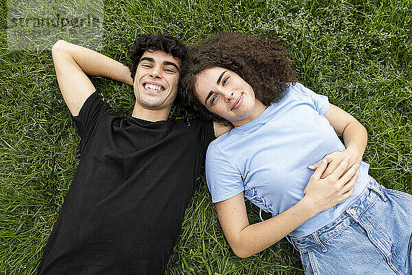 Glücklicher Mann und Frau  die auf Gras liegen
