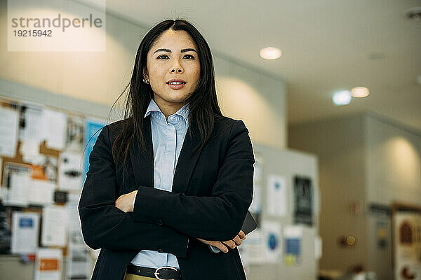Beautiful businesswoman standing with arms crossed in office