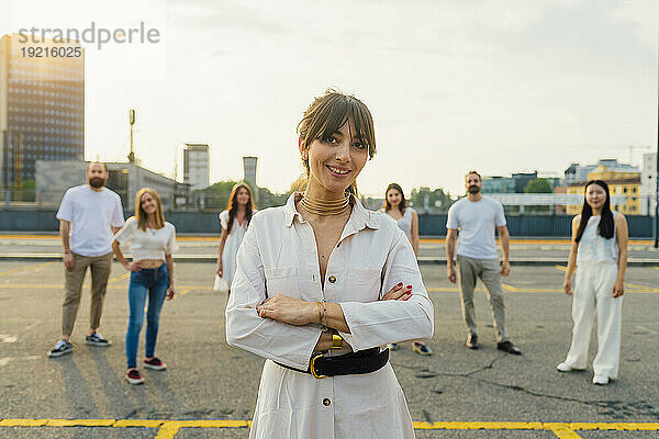 Glückliche Frau steht mit Freunden im Hintergrund auf der Straße