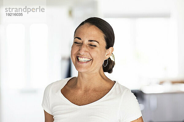 Cheerful woman wearing white t-shirt at home