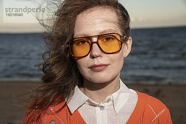 Junge Frau mit Sonnenbrille am Strand