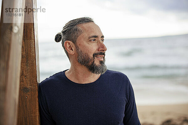 Glücklicher Mann mit Bart am Strand