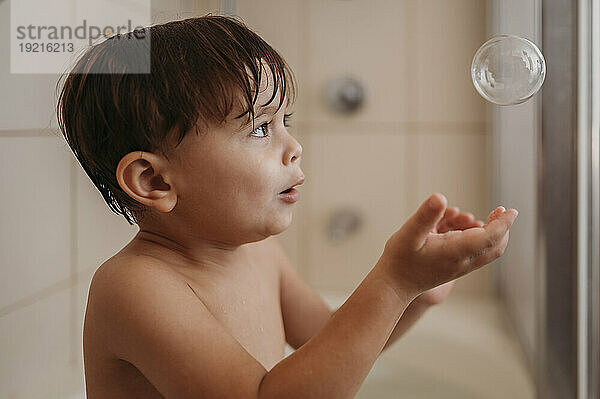 Junge fängt Seifenblase im Badezimmer