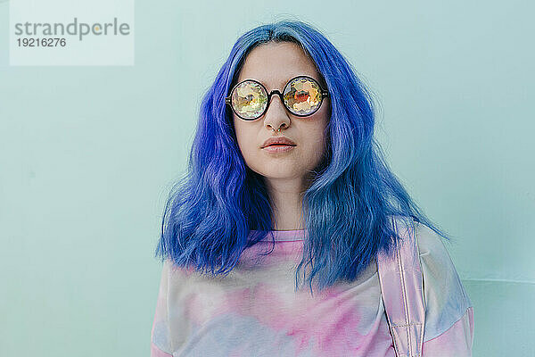 Frau mit blau gefärbten Haaren und kaleidoskopischer Brille