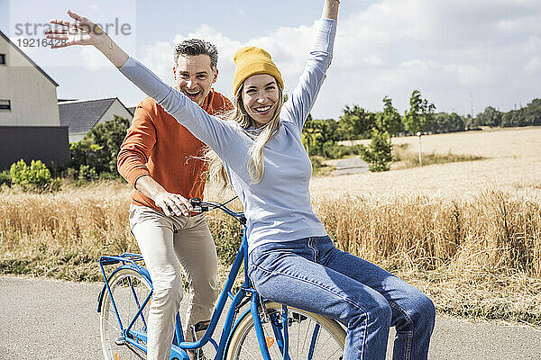 Fröhliche Männer und Frauen genießen die Radtour an einem sonnigen Tag