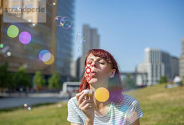 Frau bläst Seifenblasen an einem sonnigen Tag
