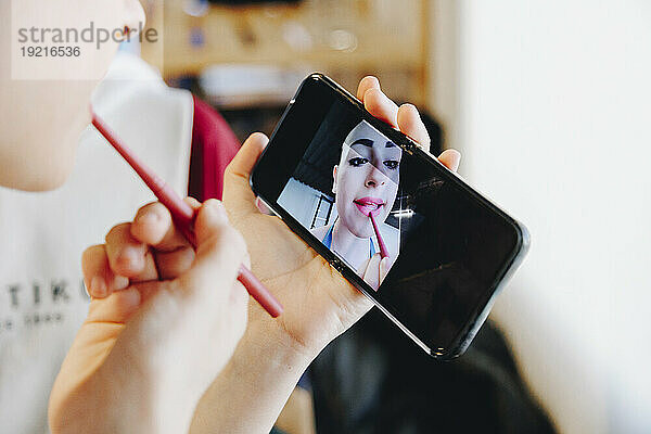 Ballet dancer applying make-up looking in smart phone
