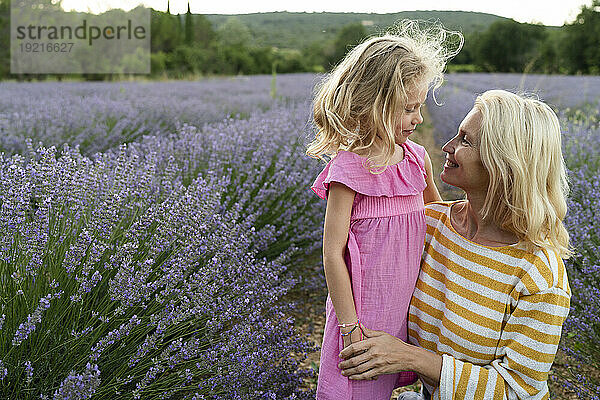 Lächelnde Frau mit Tochter im Lavendelfeld