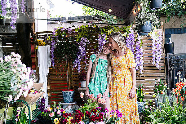 Mother and daughter standing in flower shop