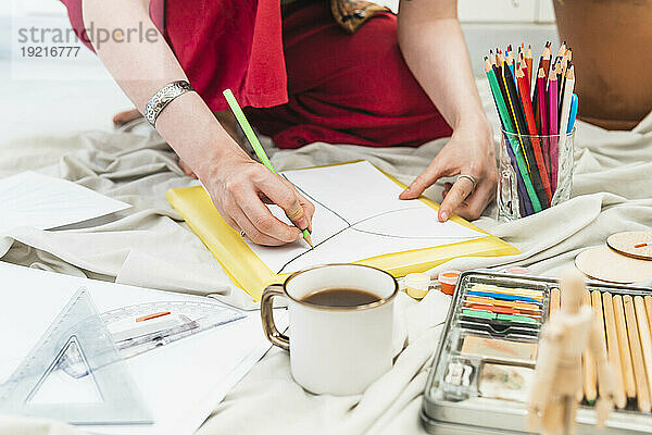 Künstler zeichnet am Tisch auf Papier