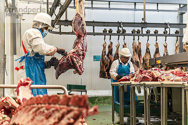 Metzger schneiden Kuhfleisch im Kühlhaus