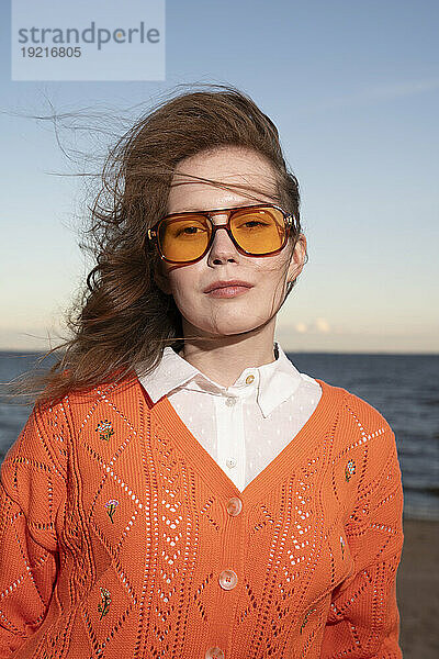 Junge Frau mit Sonnenbrille am Strand