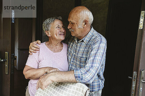 Älteres Paar umarmt sich und schaut einander an
