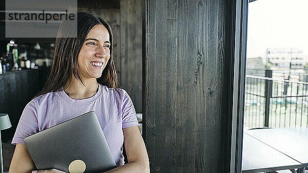 Portrait of beautiful brunette woman holding laptop