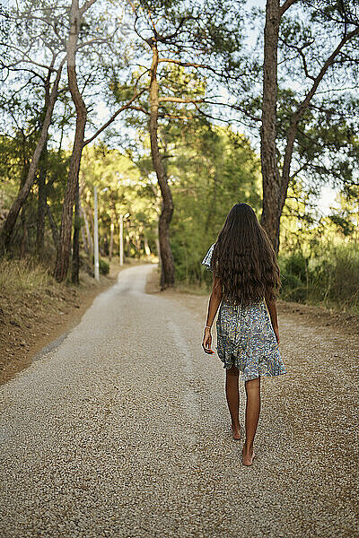 Teenager-Mädchen läuft auf der Straße im Wald