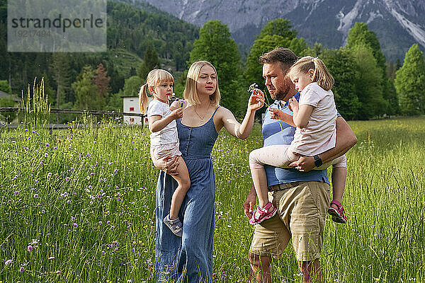 Familie verbringt Urlaub beim Spazierengehen auf Gras