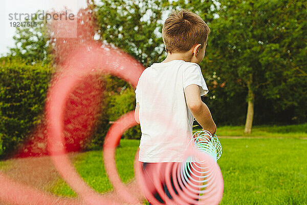 Junge spielt mit Frühlingsspielzeug im Park