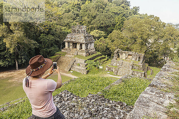 Man photographing Mayan ruins with smart phone