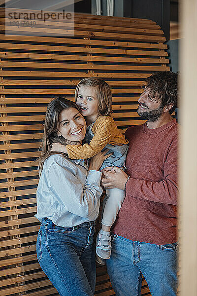 Happy family enjoying together near wooden wall at home