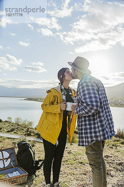 Romantisches Paar küsst sich vor dem See
