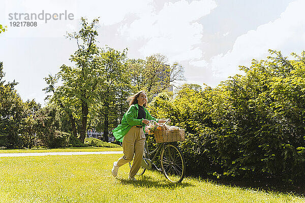 Frau mit Fahrrad am Wochenende im Park