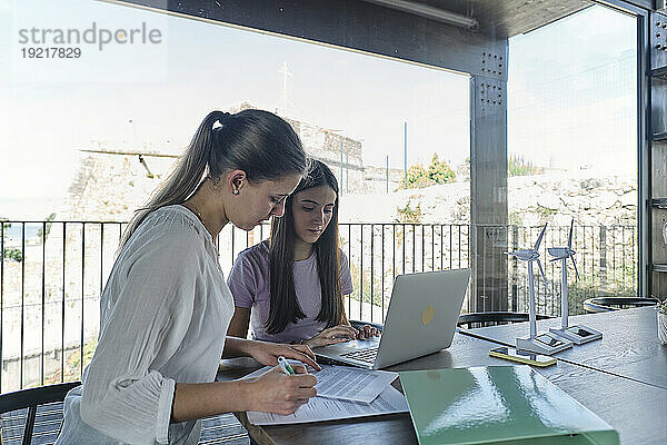 Zwei junge Ingenieurinnen arbeiten am Cafétisch zusammen
