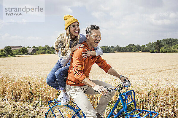 Glückliches Liebespaar genießt die Radtour vor dem Feld