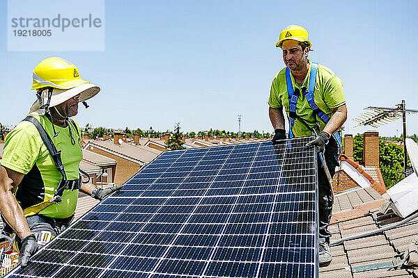 Ingenieure installieren an einem sonnigen Tag gemeinsam Sonnenkollektoren
