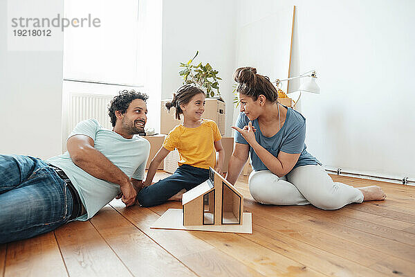 Lächelnder Vater und Tochter  Mutter gestikuliert zu Hause