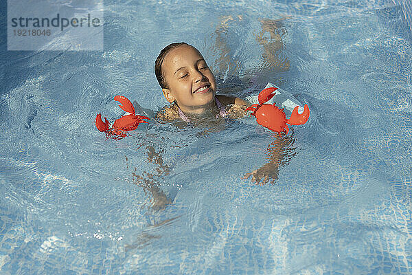 Glückliches Mädchen schwimmt im Pool