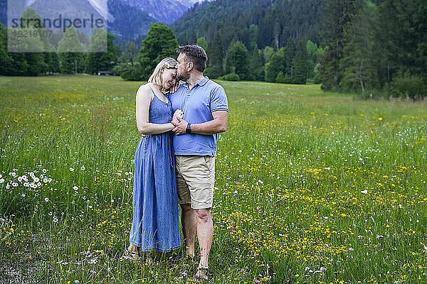 Smiling woman standing with man in meadow