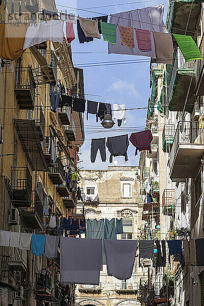 Italien  Kampanien  Neapel  Quartiere Pendino  Via Delle Zite  Wäschetrocknung an Drähten  die bis zu den Fassaden von Gebäuden gespannt sind  auf beiden Seiten der Straße  November 2021.